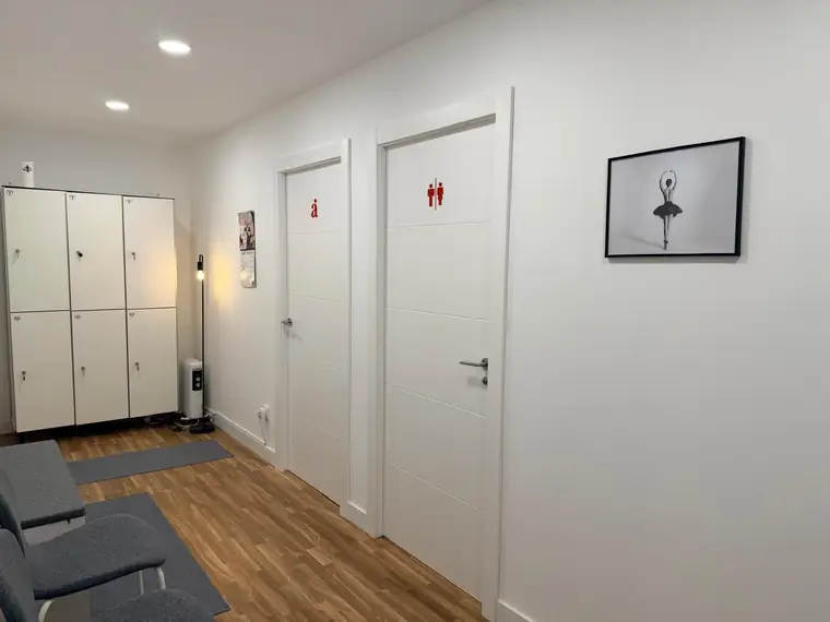 Zona de vestuario de Aria con taquillas y asientos